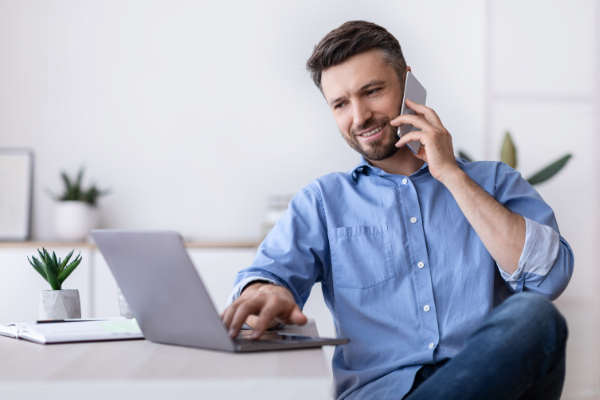 Mike Makes A Call While Looking On Laptop 600X400